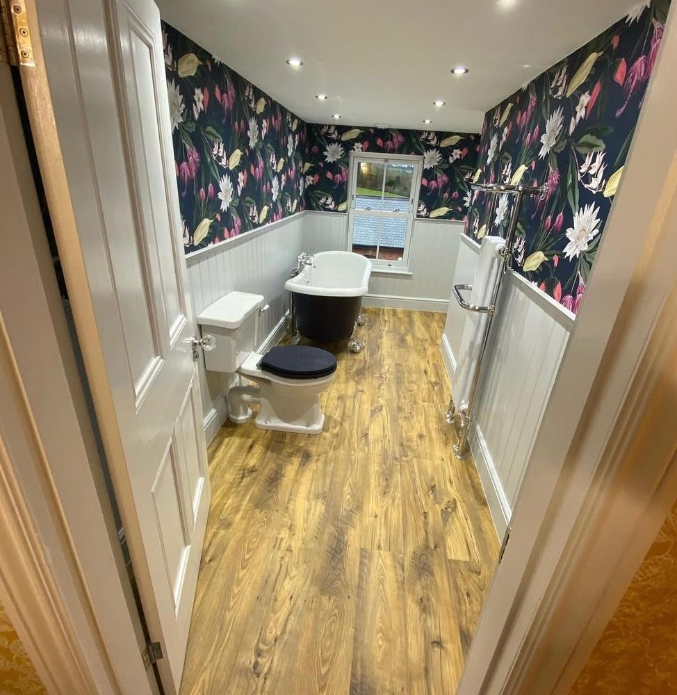 Bathroom with a roll-top slipper bath and high-level traditional WC