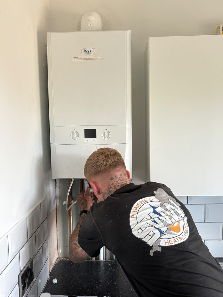SWW engineer connecting pipework on a new Ideal boiler