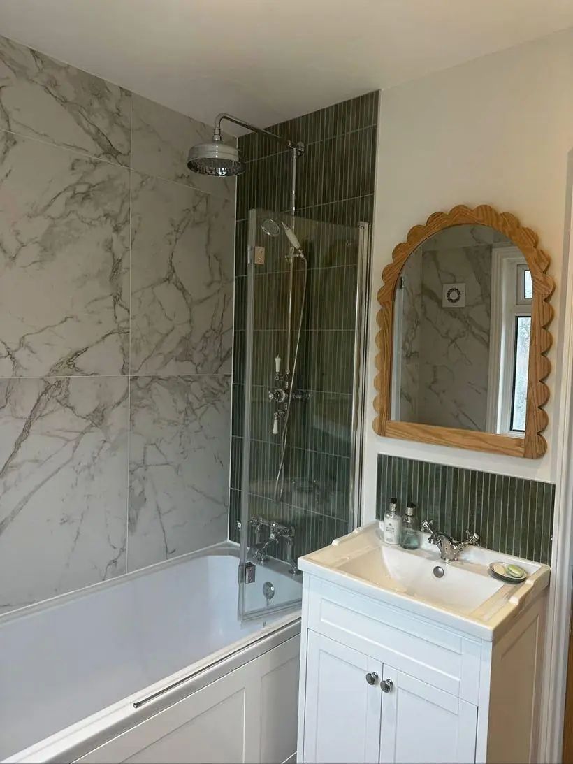 Modern bathroom with marble and green tiling, walk-in shower and vanity unit