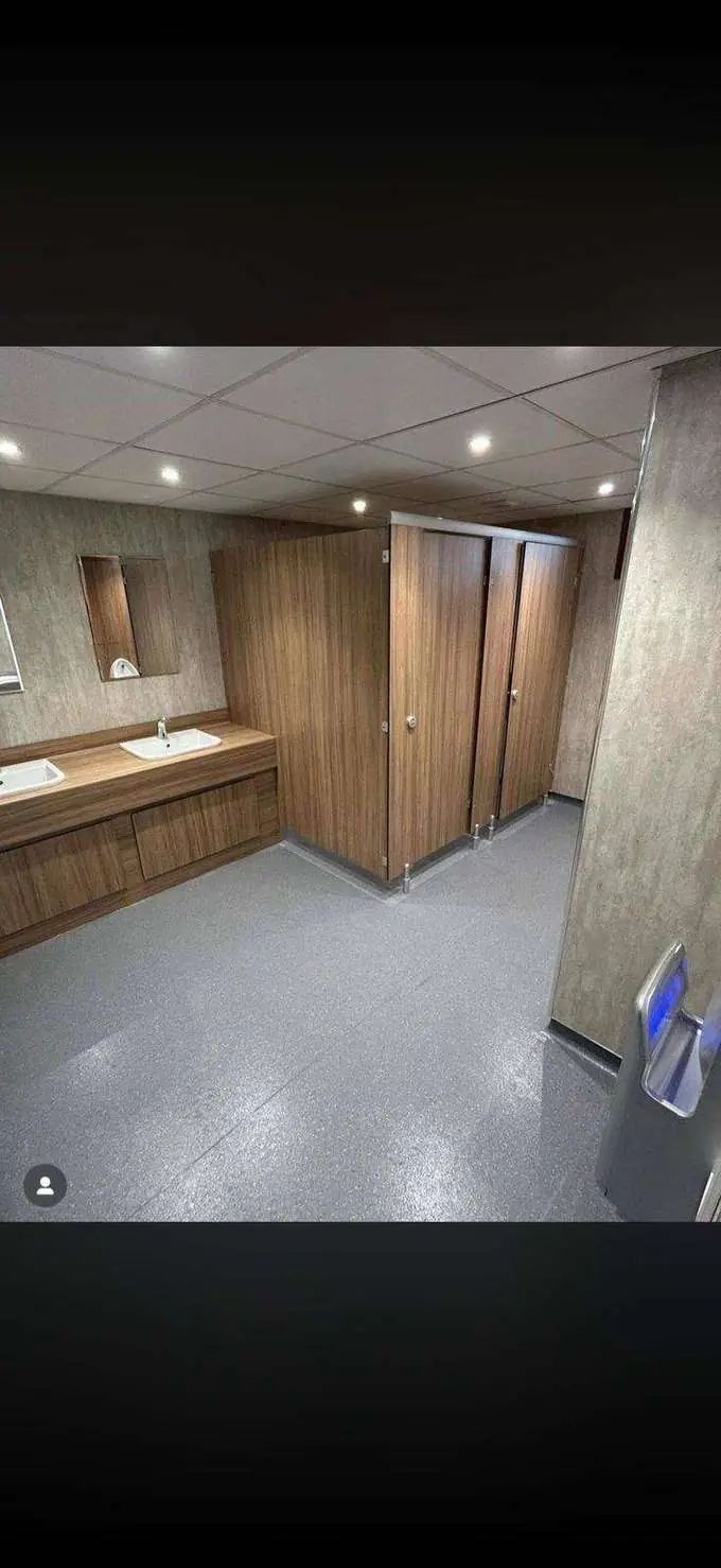 Premium commercial washroom fit out — walnut panelling, bespoke vanity and urinal surrounds