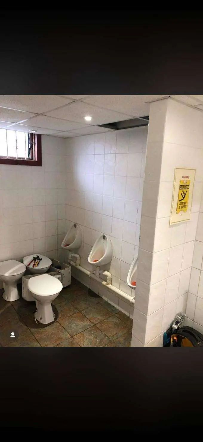Venue washroom before — stripped out, dated finishes
